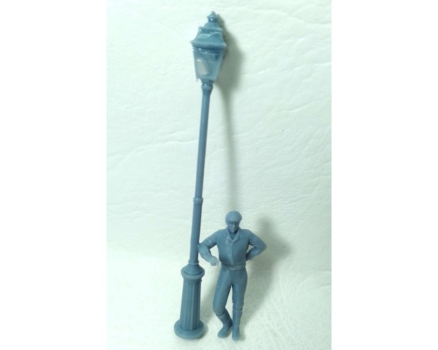 Farola con hombre apoyado con el codo.