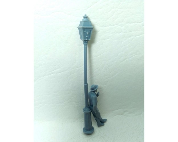 Farola con hombre apoyado fumando