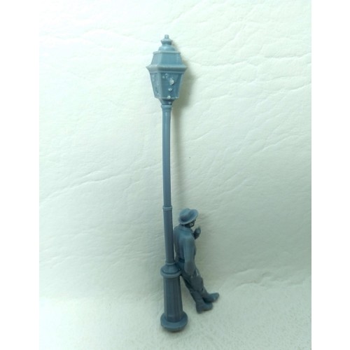 Farola con hombre apoyado fumando