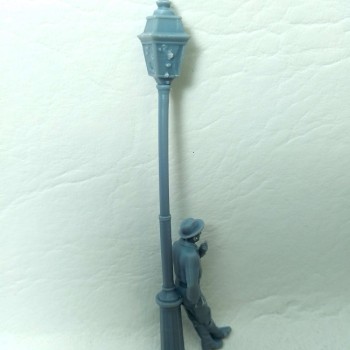 Farola con hombre apoyado fumando